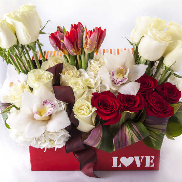 Red and white roses with orchids in a red box marked LOVE