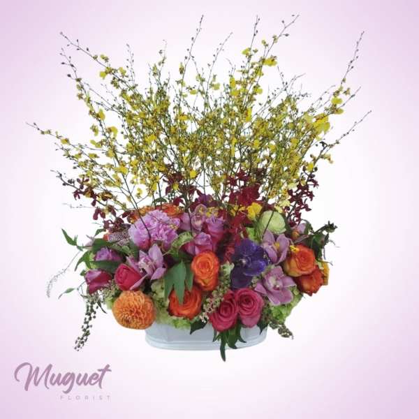 Colorful mixed flower arrangement in a low white container
