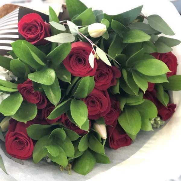 Bouquet of red roses with green foliage and white buds
