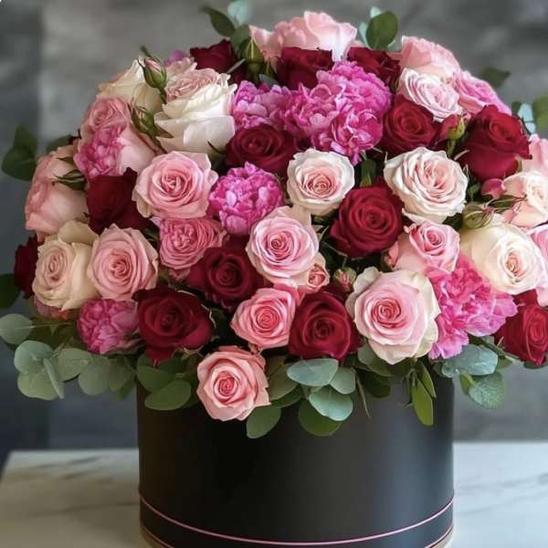 Round bouquet of pink and red roses in a black box