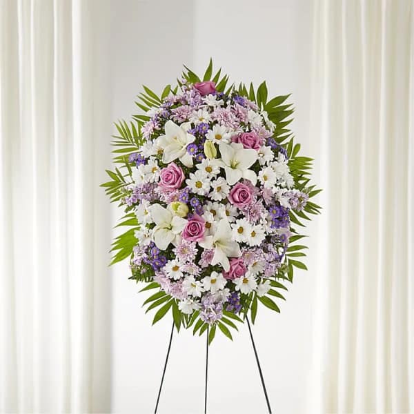 Standing floral wreath with white lilies, pink roses, and purple daisies