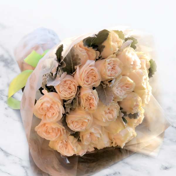 Bouquet of peach roses wrapped in translucent paper