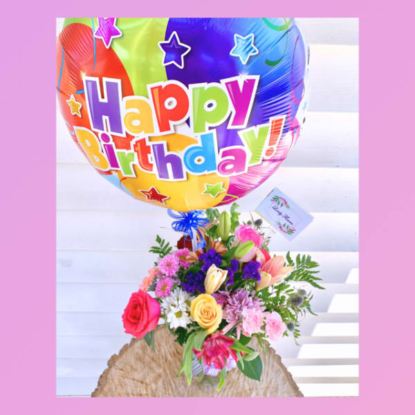 Birthday balloon above a colorful mixed flower bouquet
