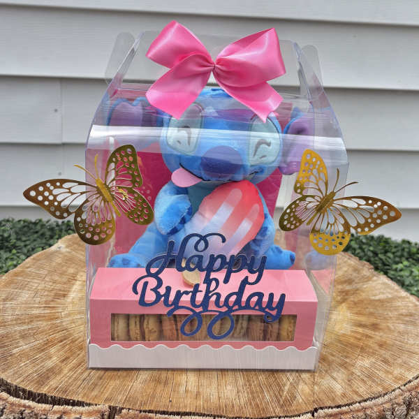 Blue plush toy in a clear gift box with pink bow and butterfly decorations