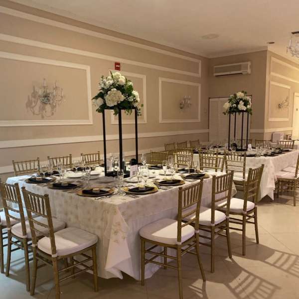 Banquet tables with tall white floral centerpieces in a formal room