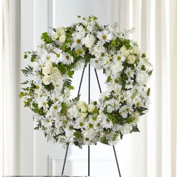 White floral wreath on a black easel