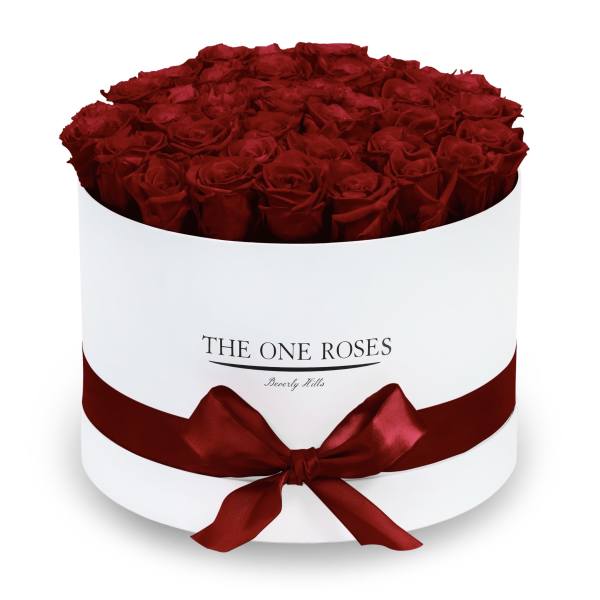 Round box filled with red roses and tied with a red ribbon