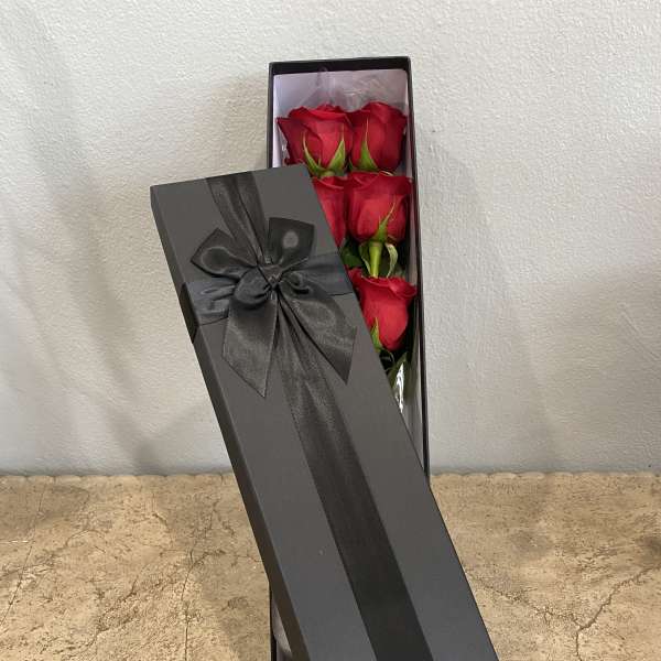 Box of red roses with a black ribbon