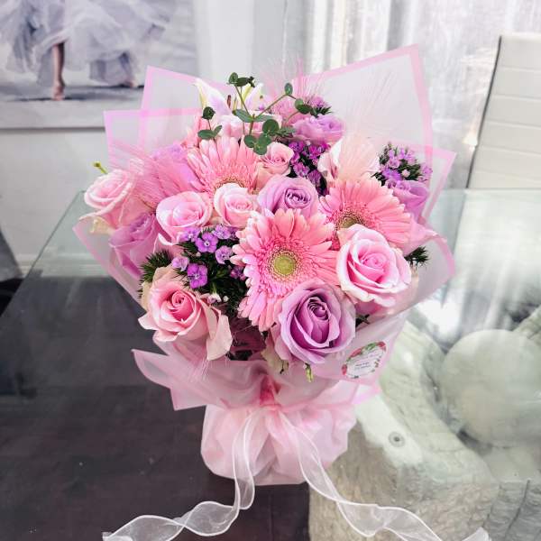 Pink rose and gerbera daisy bouquet wrapped in pink paper