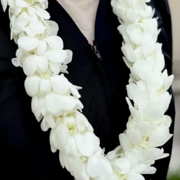 White flower lei draped over a black garment