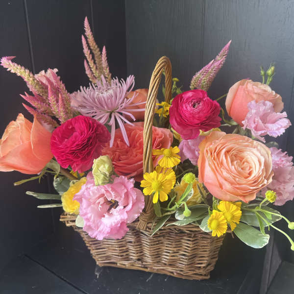 Basket of pink and peach flowers with yellow daisies