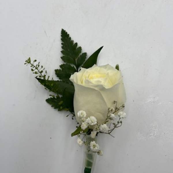 White rose boutonniere with small white filler flowers in a stem holder
