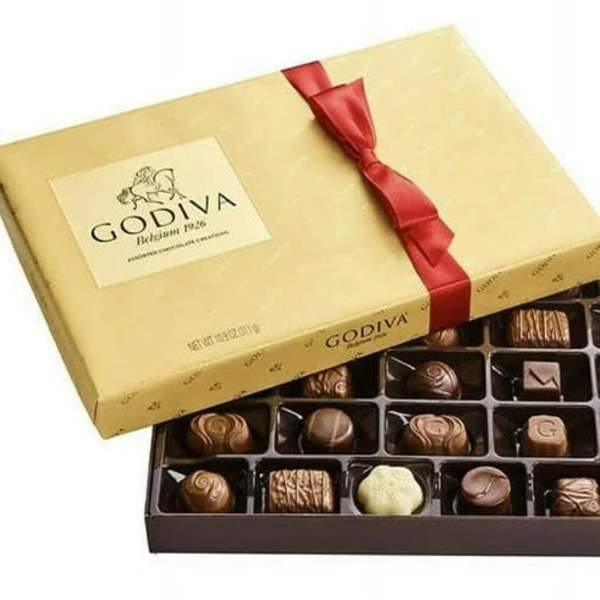 Box of assorted chocolates with a gold lid and red ribbon