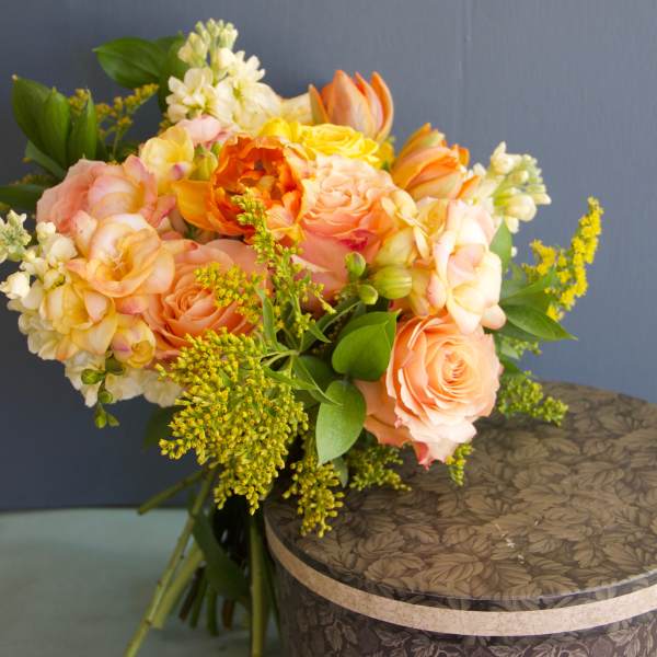 Peach and yellow bouquet of roses with white filler flowers