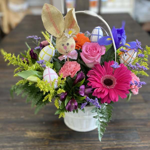 Spring bouquet in a white bucket with a bunny and painted eggs