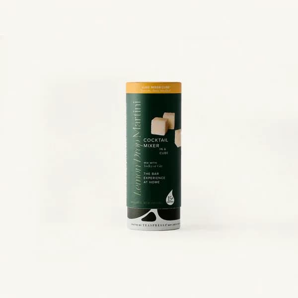 A cylindrical cocktail mixer package with a dark green label on a white background.