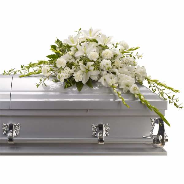 White floral spray arranged on a silver casket