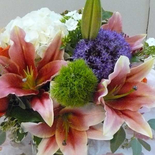 Bouquet of pink lilies, orange roses, and purple flowers