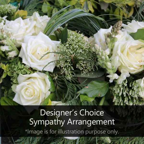 Sympathy arrangement of white roses and snapdragons with abundant green foliage.