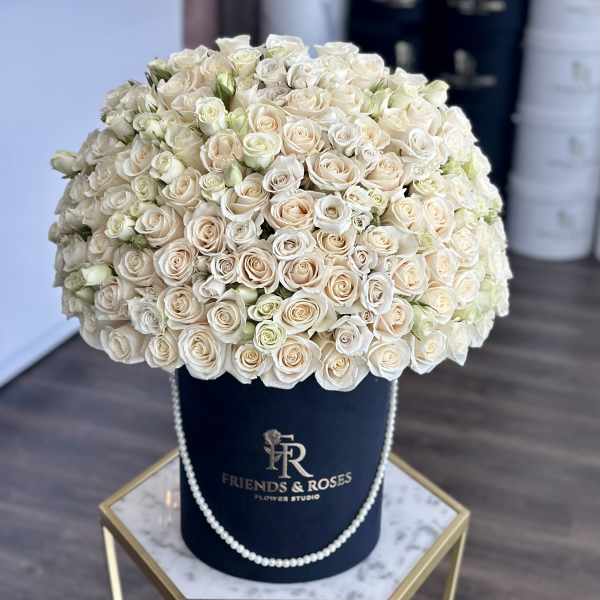 Large cream rose arrangement in a navy hat box with pearl trim