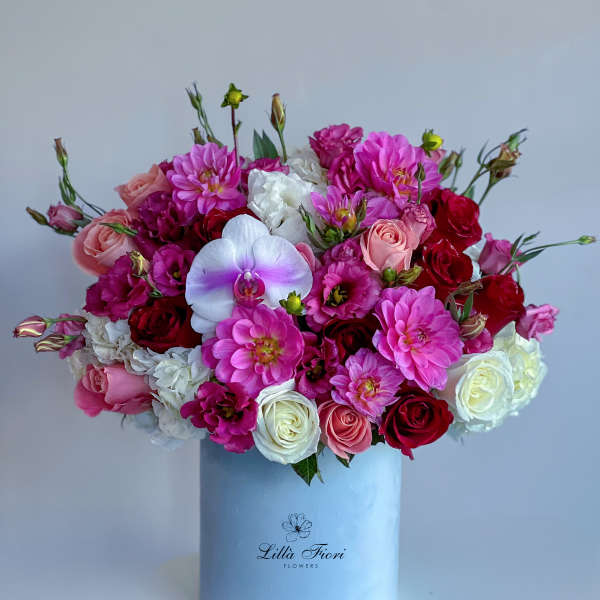 Mixed pink and white flower arrangement in a light blue box