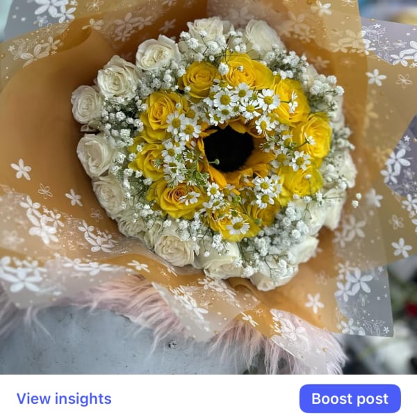 Yellow and white rose bouquet with small white daisies in floral wrap