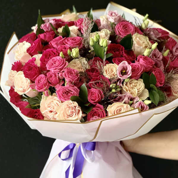 Large bouquet of pink and cream roses wrapped in white paper