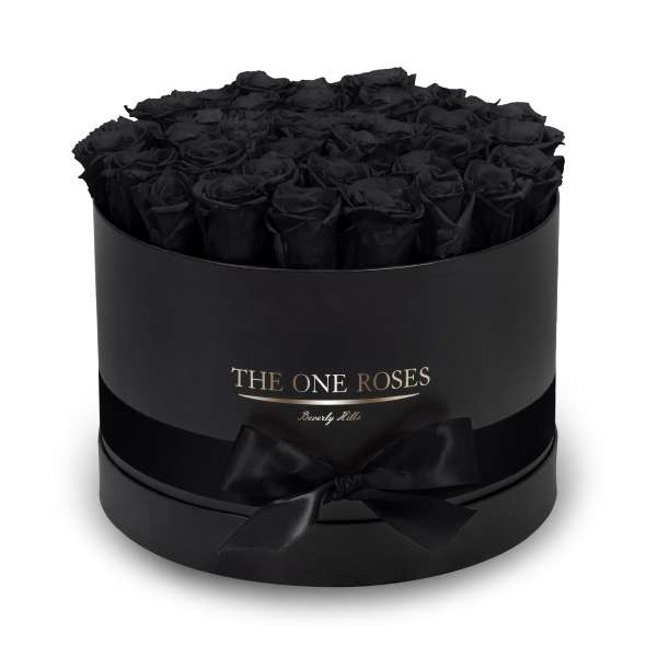 Black roses in a round black gift box with a ribbon