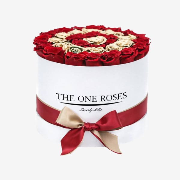 Round box of red and cream roses with a ribbon bow