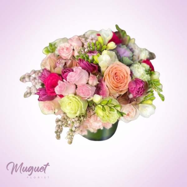 Mixed pink, peach, and white bouquet in a dark vase