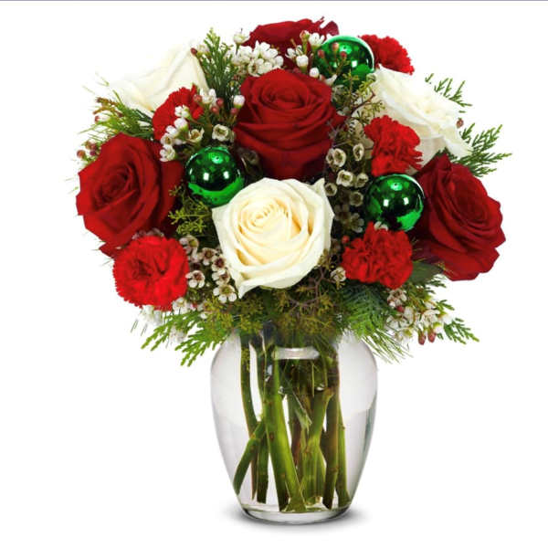 Red and white roses in a clear glass vase with green ornaments