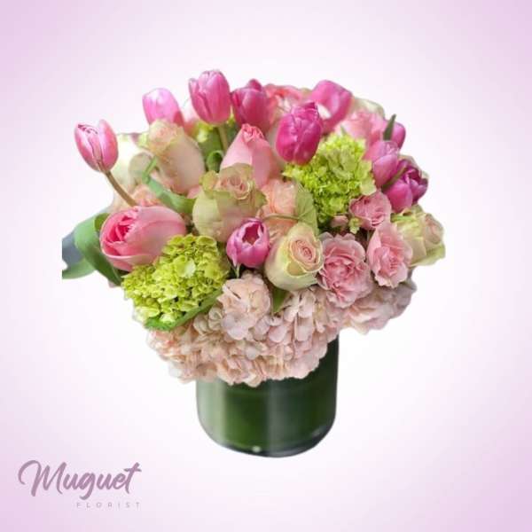 Pink tulips and roses arranged in a green vase