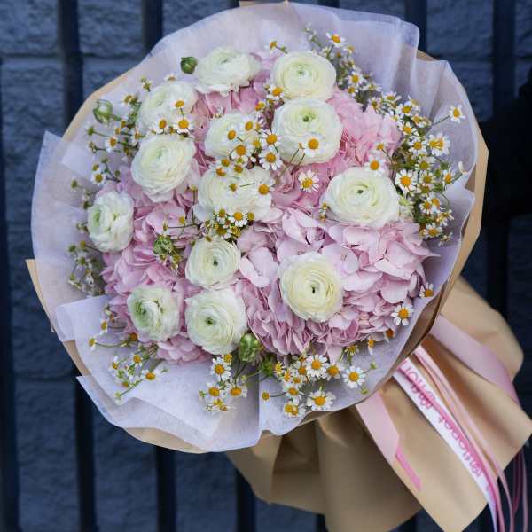 Pink hydrangea bouquet with white ranunculus and small daisies