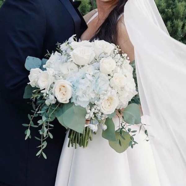 Bride holding a white rose bouquet with eucalyptus