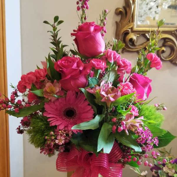 Pink rose and gerbera bouquet with a bright ribbon on a stand