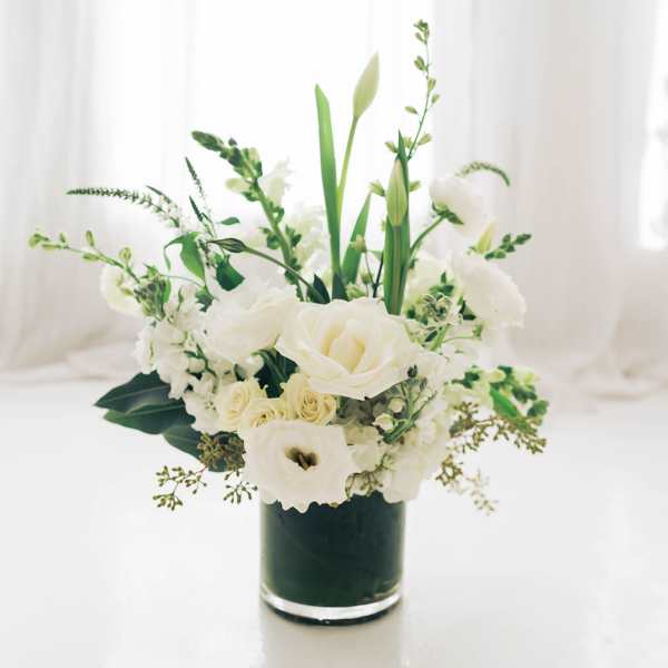 White floral arrangement in a dark glass vase