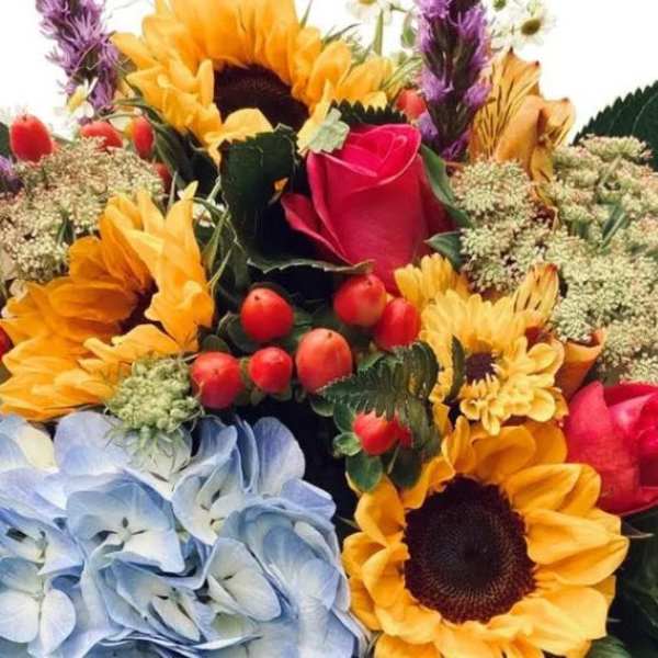 Mixed bouquet with sunflowers, roses, and blue hydrangeas