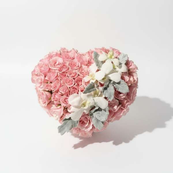 Heart-shaped bouquet of pink roses with white orchids