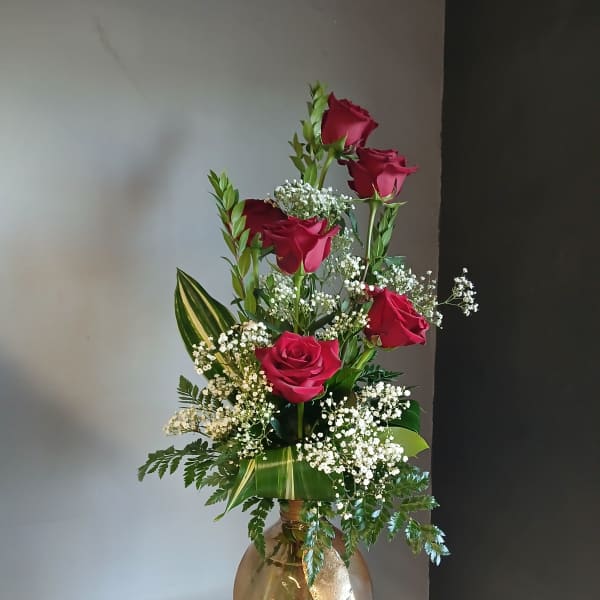 Tall vase arrangement of red roses with white baby's breath