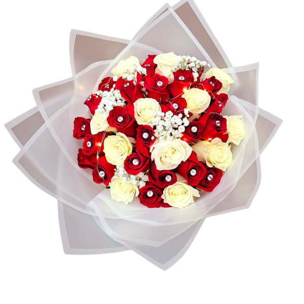 Bouquet of red and cream roses wrapped in translucent paper