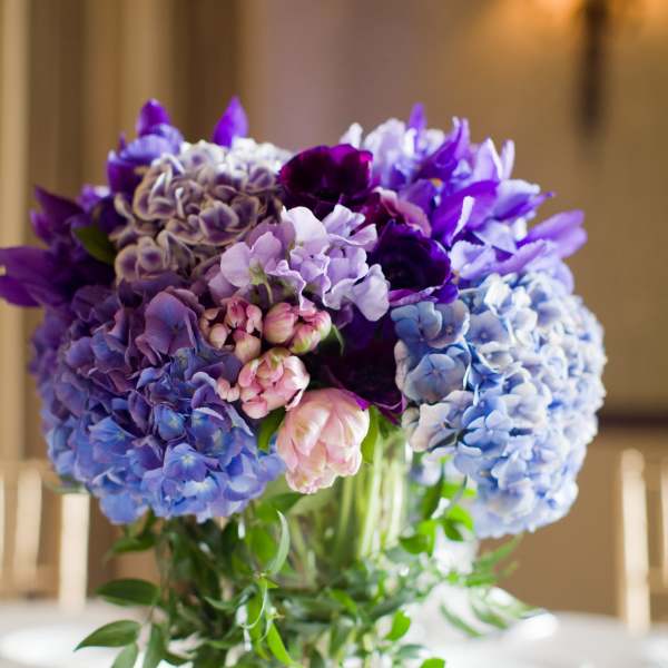 Purple and blue hydrangea bouquet in a clear glass vase
