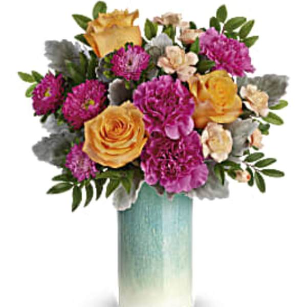 Arrangement of yellow roses and purple carnations in a tall blue and white ceramic vase