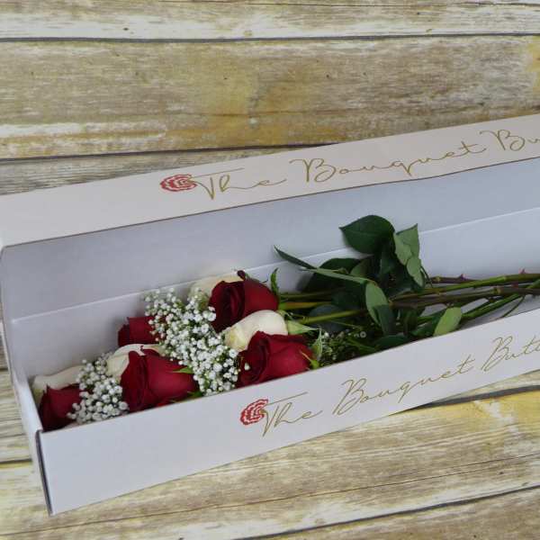 Red and white roses in a white bouquet box