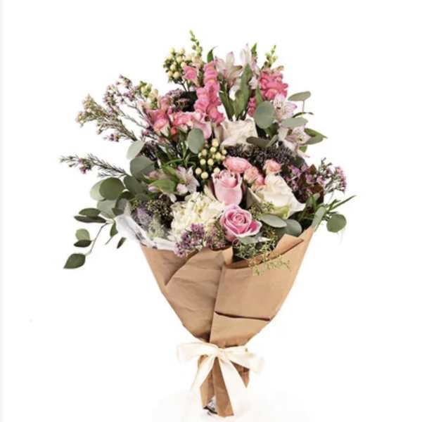 Pink and white mixed bouquet wrapped in brown paper with a ribbon