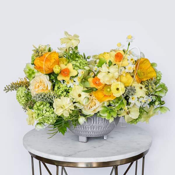 Yellow and white floral arrangement in a gray bowl vase