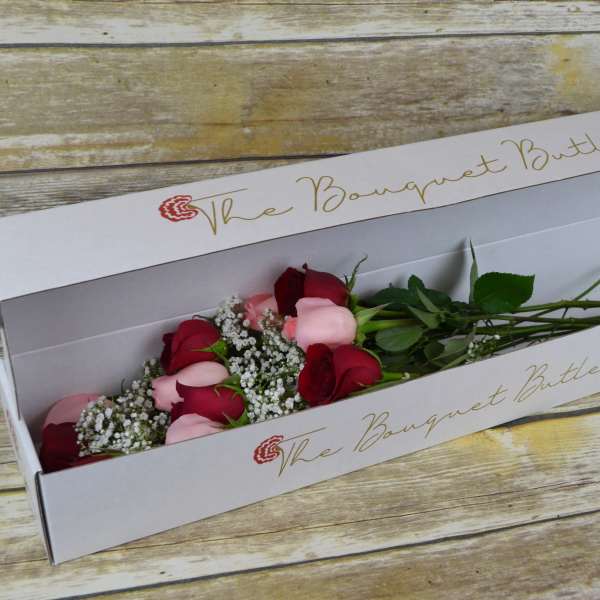 Boxed bouquet of red and pink roses with baby's breath