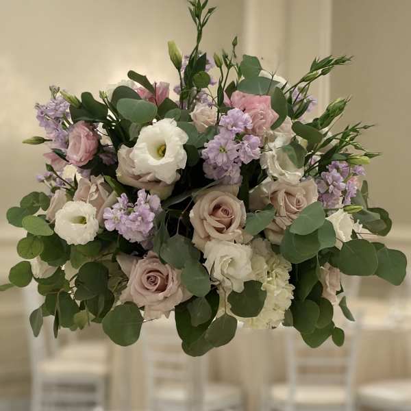 Tall floral centerpiece with blush roses, white blooms, and lavender accents