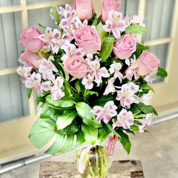Pink roses and white alstroemeria in a glass vase