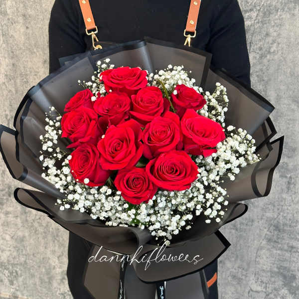 Bouquet of red roses with white baby's breath in black wrap