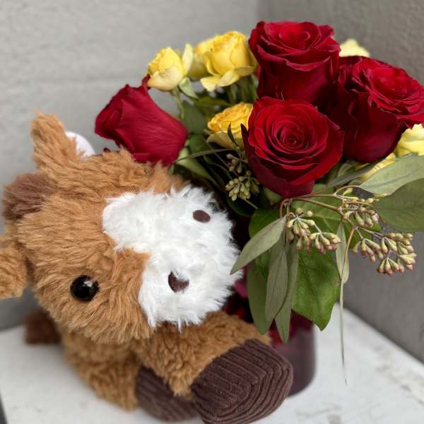 Red and yellow roses with a plush teddy bear